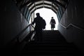 People go down the stairs. Silhouettes of people in the tunnel Royalty Free Stock Photo