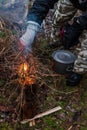 People are going to cook food in a pot on Swedish Fire Log. Burning a Swedish candle, torch in winter evening Royalty Free Stock Photo