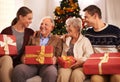 People, grandparents and family with Christmas gift for festive season together for celebration, presents or holiday Royalty Free Stock Photo