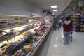 People grocery shopping at the meal counter inside a stored