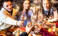 People group celebrating Christmas toasting champagne wine at home dinner party - Winter holiday concept with young friends Royalty Free Stock Photo