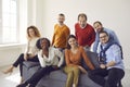 People group of different age and ethnicity sitting on sofa looking at camera