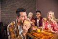 People Group Eating Fast Food Burgers Sitting At Wooden Table In Cafe Royalty Free Stock Photo