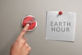 People hand with Earth hour note turning off electrical equipment Royalty Free Stock Photo