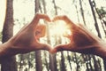 people hand hearts shape with sunshine