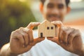 people hand holding miniature wooden house model for banking housing mortgage real estate rent lease home family concept Royalty Free Stock Photo