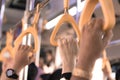 People hand holding yellow handle on the bus