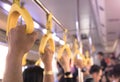 People hand holding yellow handle on the bus