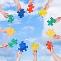 People hands with puzzle pieces with blue sky Royalty Free Stock Photo