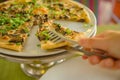 People hands taking slices of pizza. Table with pizza in a restaurant. Pizza and hands close up on a green