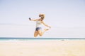 People happines concept for summer holiday vacation leisure activity at the beach - young crazy beautiful blonde woman jump with Royalty Free Stock Photo