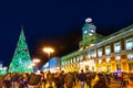 People have fun in Christmas time passing the famous illuminated christmas tree at puerta del sol in Madrid, Spain