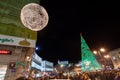 People have fun in Christmas time passing the famous illuminated christmas tree at puerta del sol in Madrid, Spain