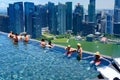 Infinity pool on the roof terrace of the Marina Bay Sands hotel in Singapore. People have fun at a height of 200 meter with view