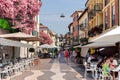 People have lunch on a hot afternoon on the open verandas of restaurants in the Lazise town near Lake Garda Royalty Free Stock Photo