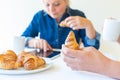 People having breakfast in the morning with croissant and coffee while reading news Royalty Free Stock Photo