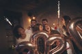 People having fun at New Years party, waving with sparklers and holding 2020 balloons Royalty Free Stock Photo