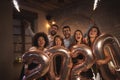 People having fun at New Years party, waving with sparklers and holding 2020 balloons Royalty Free Stock Photo