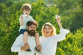 People having fun outdoors. Portrait of happy father giving son piggyback ride on his shoulders and looking up. Concept Royalty Free Stock Photo