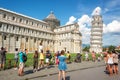 People having fun and taking pictures of the leaning tower of Pisa in Tuscany Italy