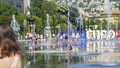 People having fun walking through water mirror fountain at Promenade du Paillon