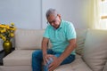 People, health care and concept medical problem - unhappy older man suffering from knee pain at home
