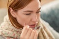 Sick woman in scarf taking cough syrup at home Royalty Free Stock Photo