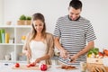 Happy couple cooking food at home kitchen Royalty Free Stock Photo