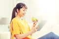 Happy asian woman with tablet pc and apple at home Royalty Free Stock Photo