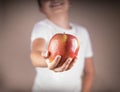 People, healthy food, children and happiness concept. child gives an apple smiling.