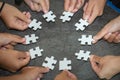 People helping in assembling puzzle, cooperation in decision making, team support in solving problems and corporate group teamwork Royalty Free Stock Photo