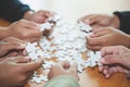 People helping in assembling puzzle, cooperation in decision making, team support in solving problems and corporate group teamwork Royalty Free Stock Photo