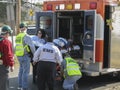 People helping to put into the ambulance sick men.