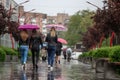 People hide from rain under umbrellas in a rainy day on the street of the city Bad weather concept