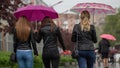 People hide from rain under umbrellas in a rainy day on the street of the city Bad weather concept