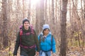 People, hike, adventures, tourism and nature concept - Young woman and man walking in forest with backpack Royalty Free Stock Photo