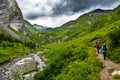 People Hike Through Alpine Valley With River To Mountain Peak Grossglockner in Tirol in Austria