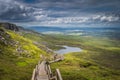 People hiking on steep stairs of wooden boardwalk in Cuilcagh Mountain Park Royalty Free Stock Photo
