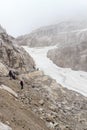 People hiking towards col Bocca del Tuckett on snow field in Brenta Dolomites mountains, Italy