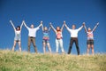 People on hill raise hands together Royalty Free Stock Photo
