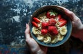 people holding a bowl of oatmeal with strawberries and bananas