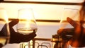 People holding glass of wine, making a toast over sunset. Friends drinking white wine, toasting. Clink. Party outdoors Royalty Free Stock Photo