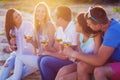 People holding glasses of white wine at the beach picnic