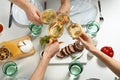 People holding glasses of white wine over table with tasty snacks Royalty Free Stock Photo