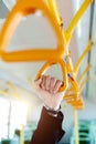 People holding handle on train