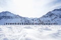 People holding hands as a sign of peace with the mountains in the background in winter