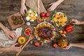 people holding hands, thanksgiving dinner served on wooden background, cooked turkey or chicken with vegetables