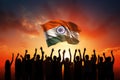 People Holding India Flag in the Air with a Dramatic Sunset Background, Silhouette of a group of people waving Indian flags in Royalty Free Stock Photo