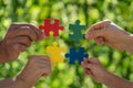 People holding multicolor jigsaw puzzle in hands