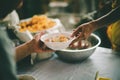 People holding a plate receiving a donation from a good friend, the concept of giving with care